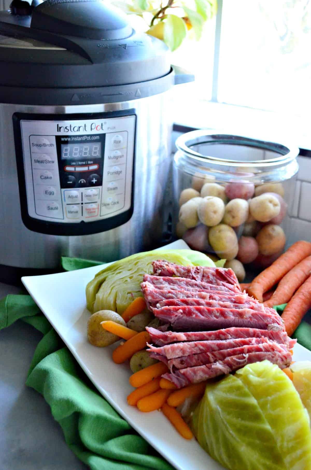 Instant Pot Corned Beef & Cabbage plated with Instant Pot in the background.