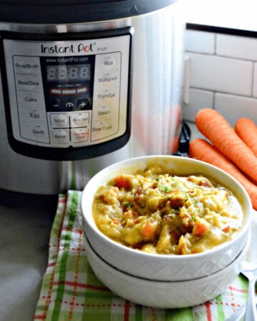 White bowls stacked with soup with an Instant Pot and carrots in background.