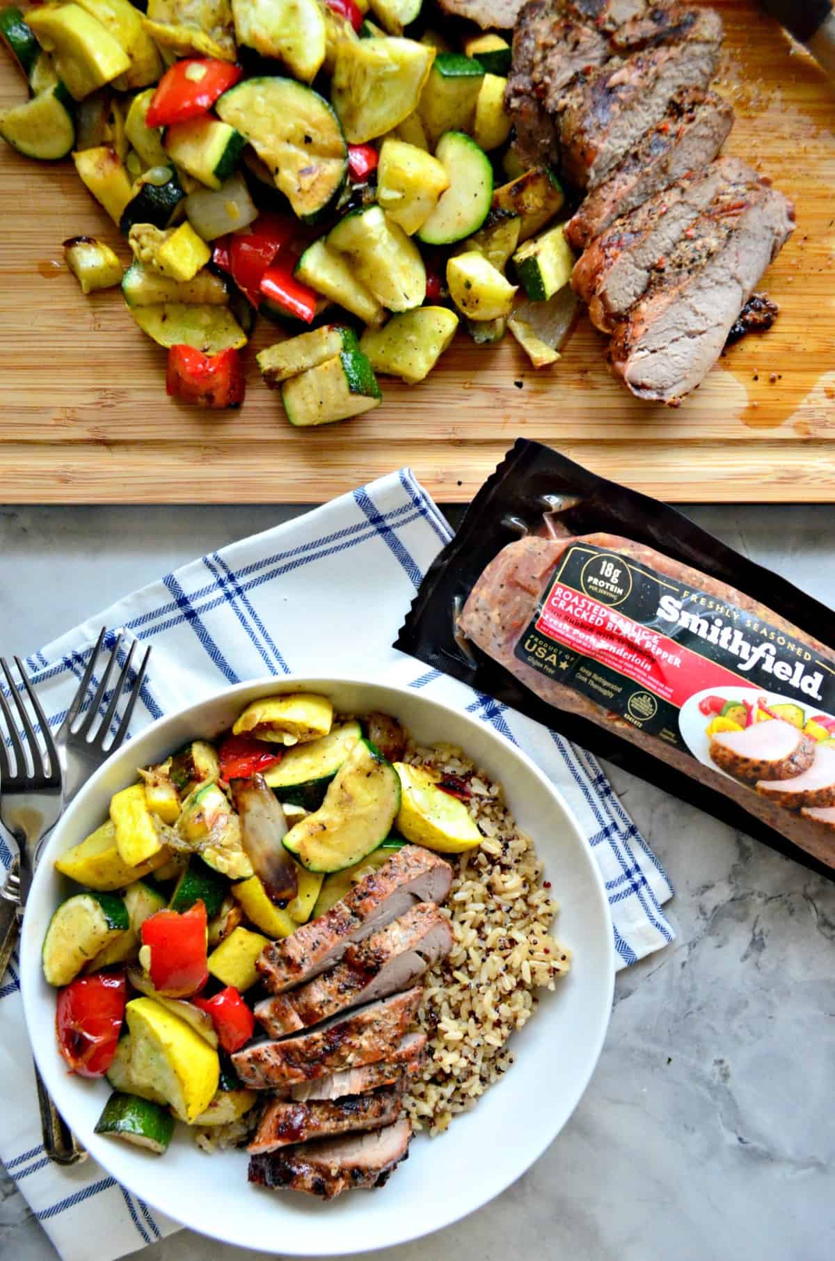 Pork Tenderloin and Brown Rice in a bowl with grilled squash, tomatoes, onions, and with title text.