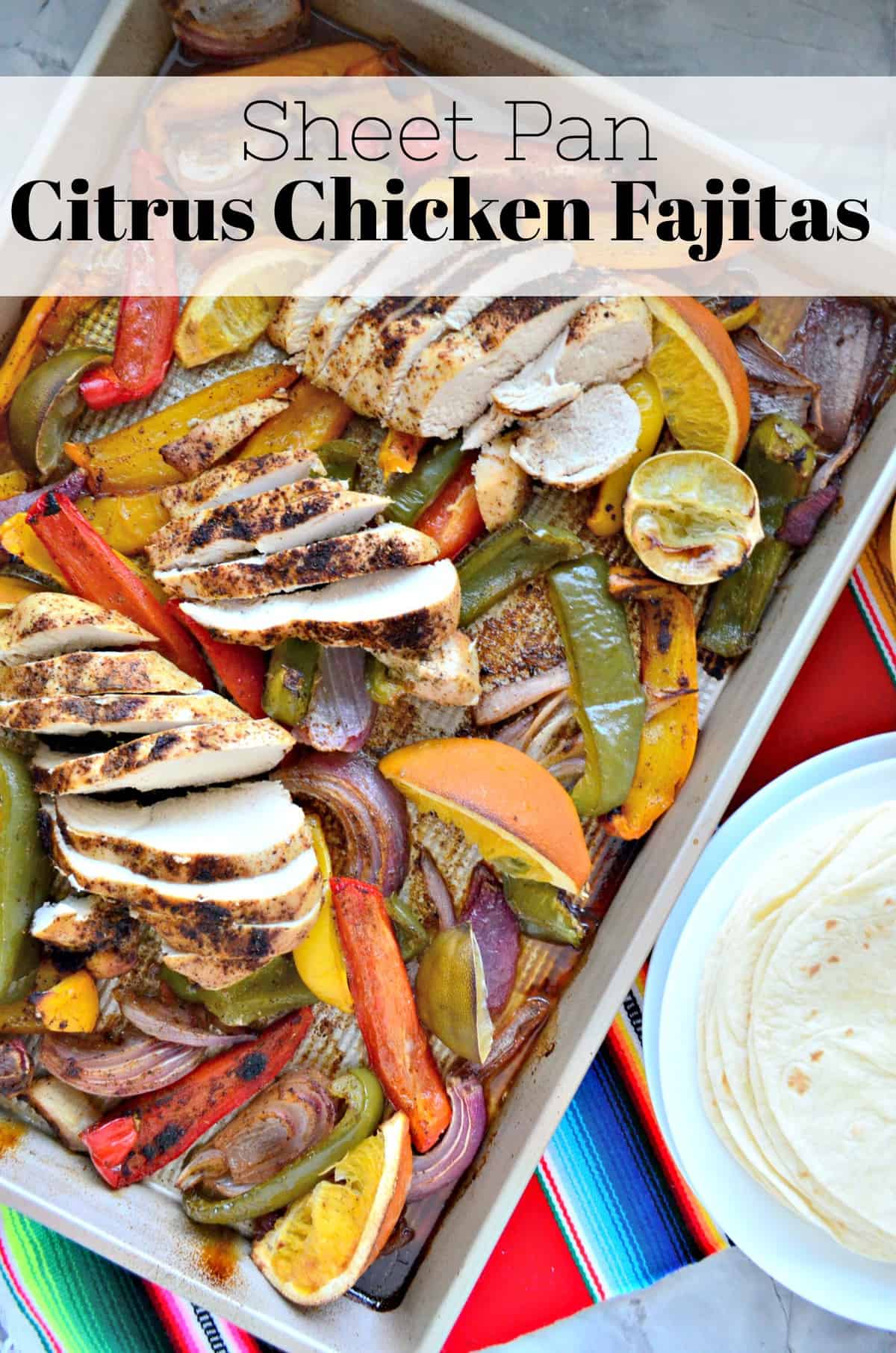 top view of sliced bell peppers, sliced chicken, lemon, and onion on sheet pan with title text.