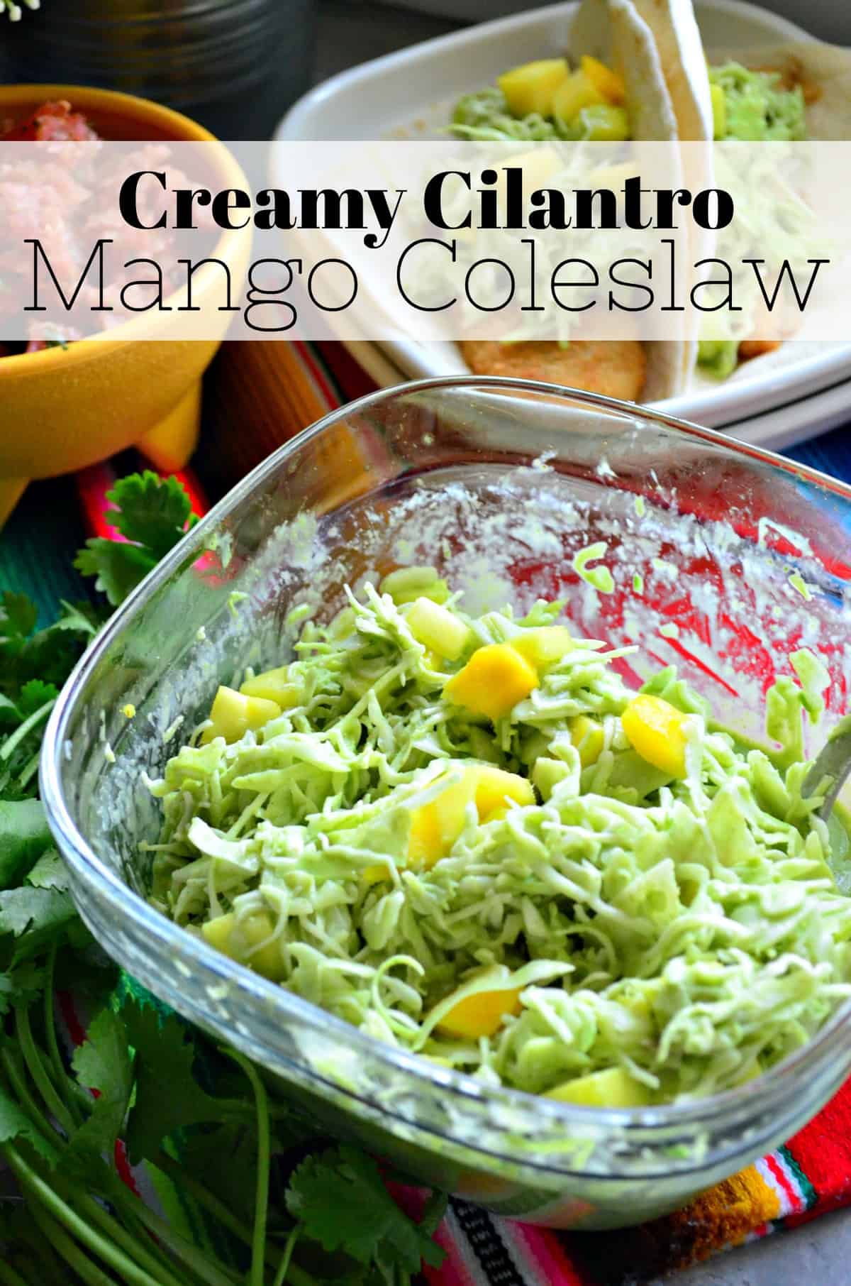 Top view of shredded green bits in glass bowl with cubed mango and green sauce with title text.