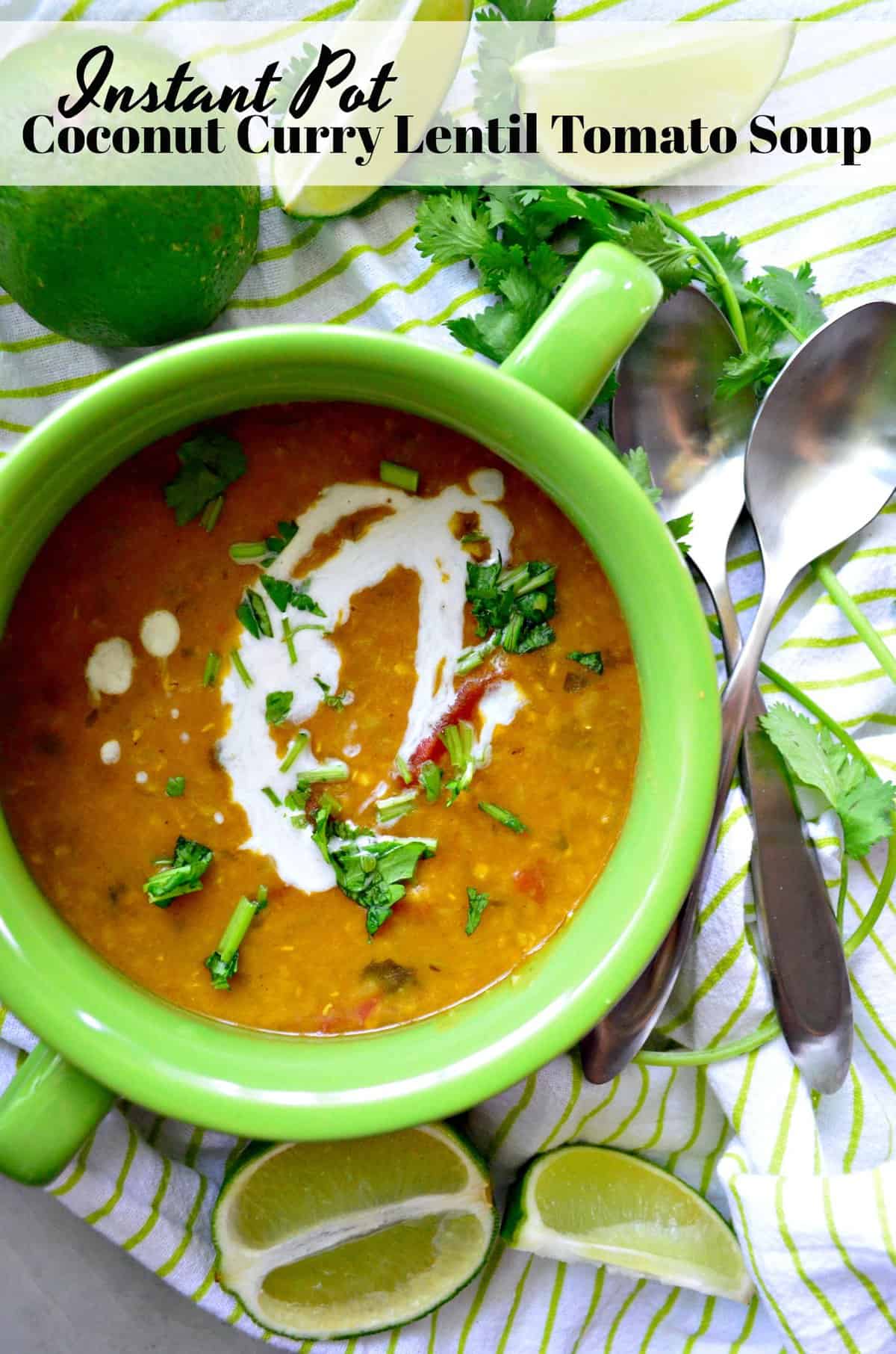 top view of bowl of lentil soup topped with white sauce, and herbs next to spoons.