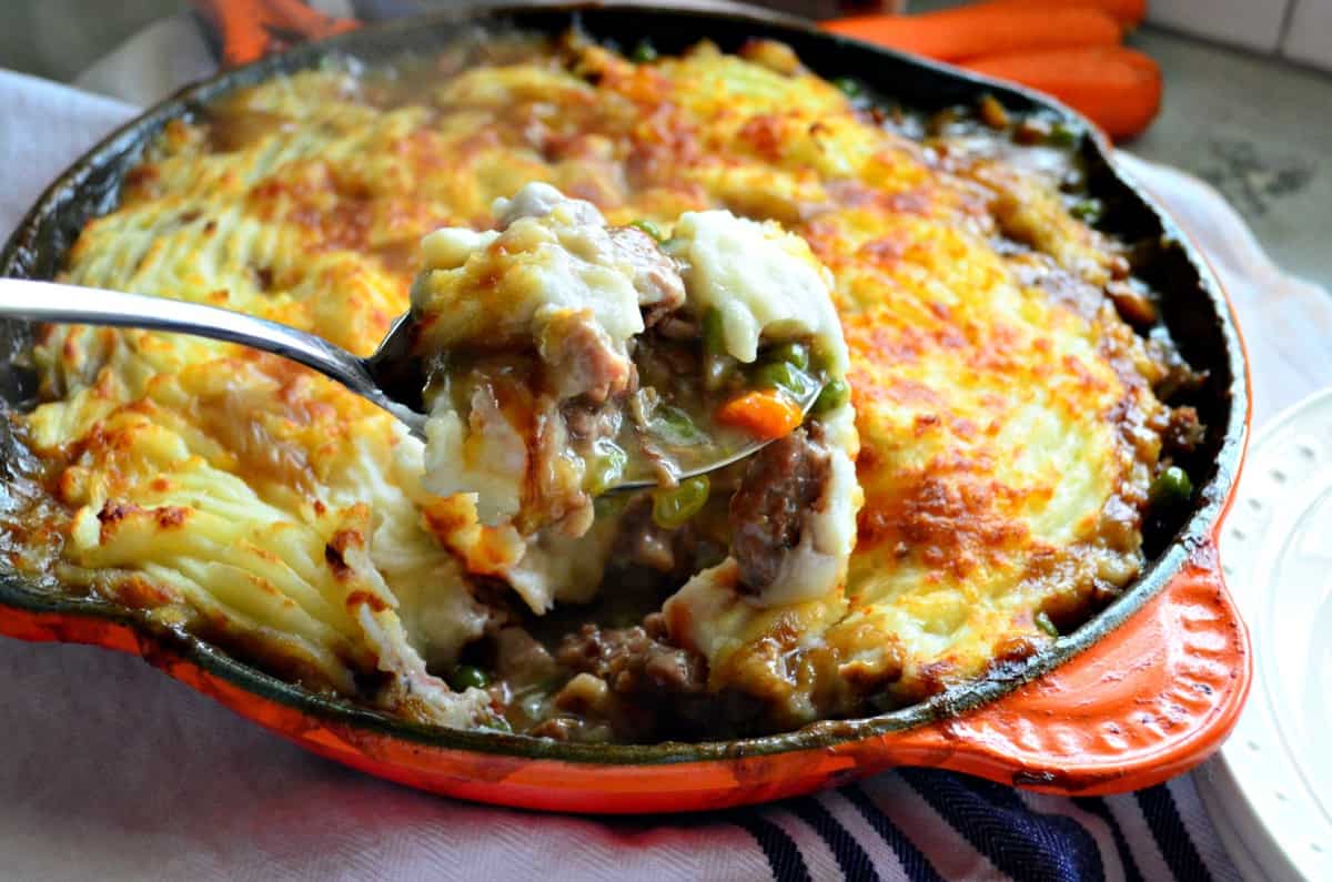 spoon scooping out a bite of shepards pie from skillet.