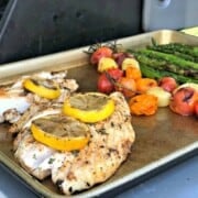 Baking sheet with snapper, blistered tomatoes, and asparagus.