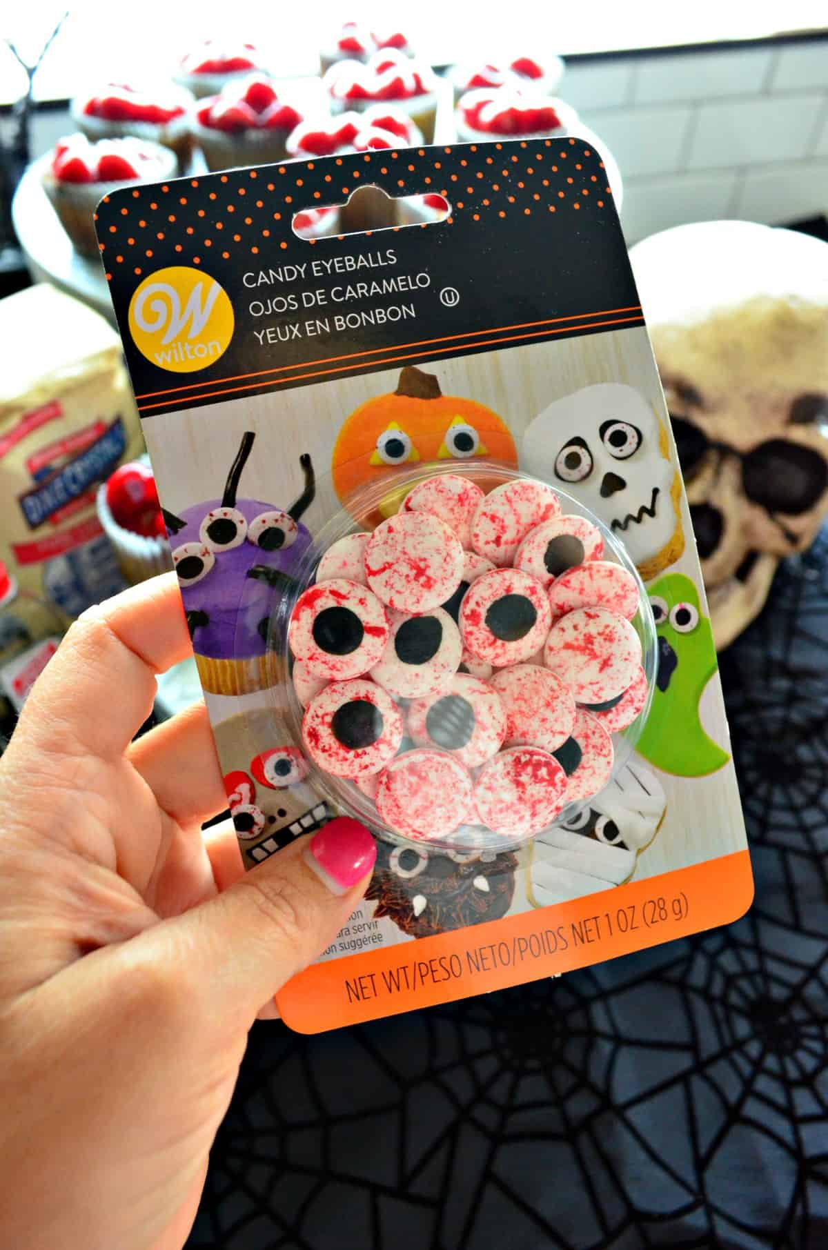 hand holding up package of Wilton Candy Eyeballs.