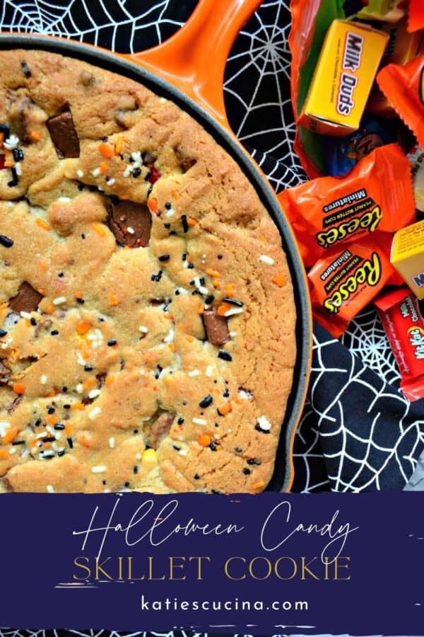 Top view of a skillet with cooked cookie and candy with text on image for Pinterest