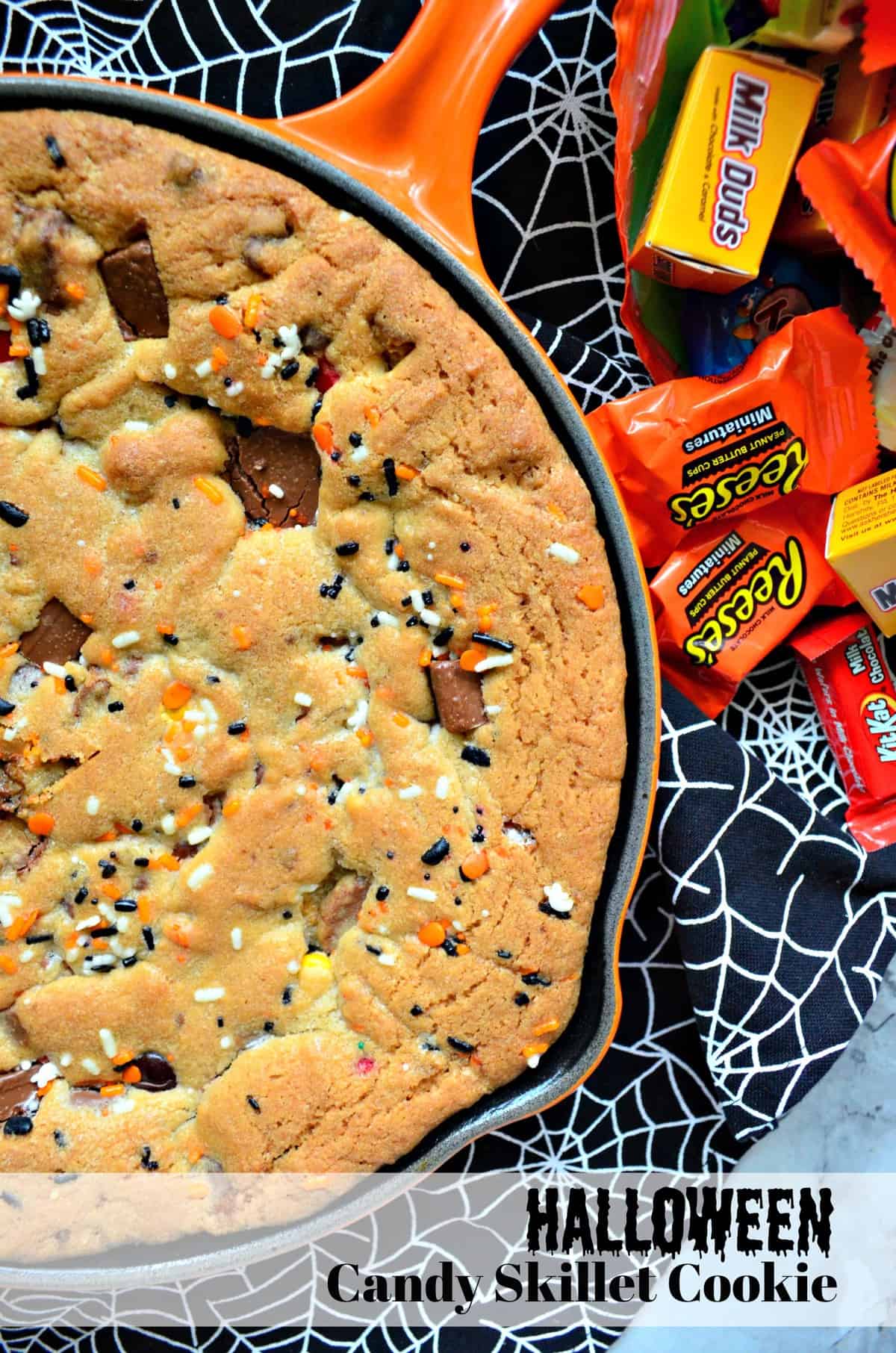 top view of a cookie with sprinkles and reeses pieces baked into a skillet with title text.