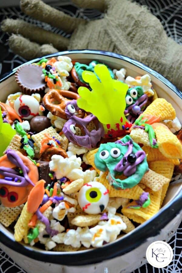 Close up of a bowl filled with popcorn, bugels, pretzels, and sweet treats.