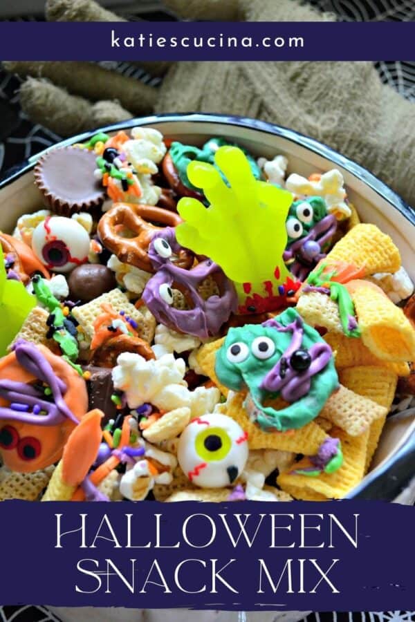 Close up of a bowl full of Halloween Snack Mix with recipe title text on image for Pinterest.