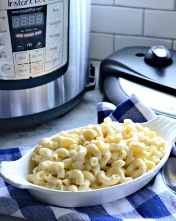 White oval dish filled with macaroni and cheese with Instant Pot in the background.