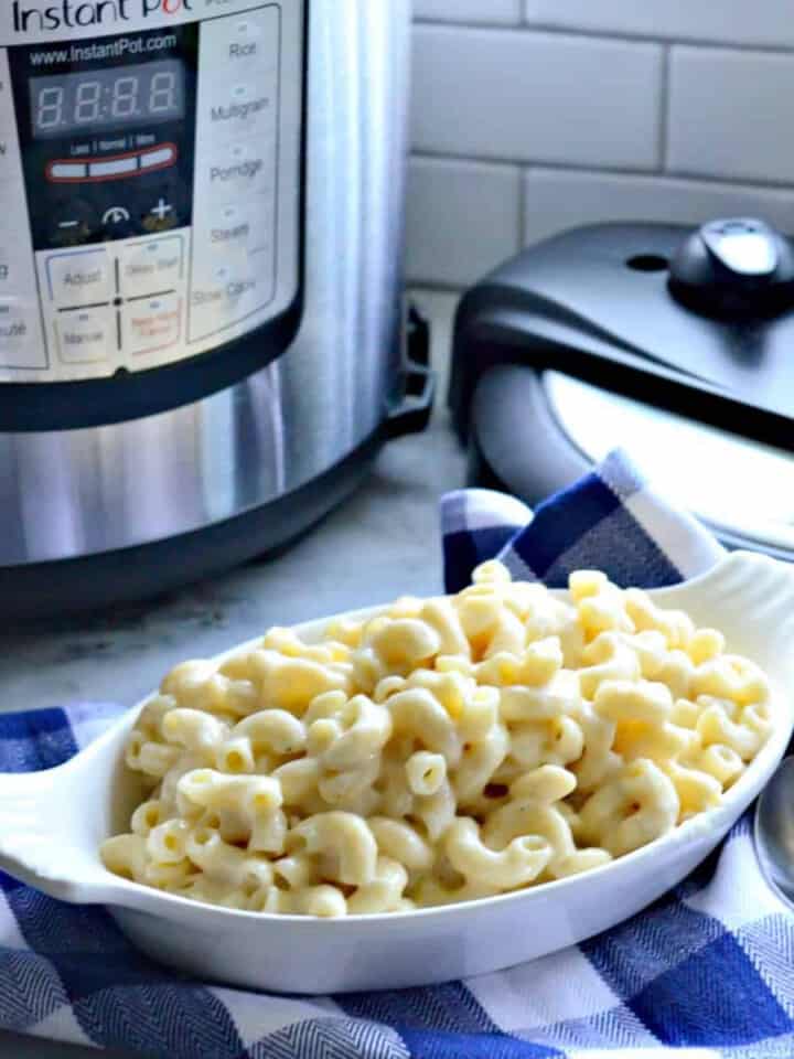 White oval dish filled with macaroni and cheese with Instant Pot in the background.