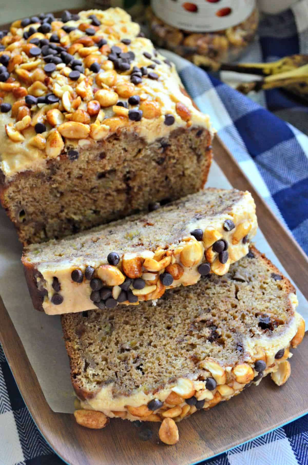 closeup of banana bread smothered in light brown mixture topped with nuts and chocolate chips.