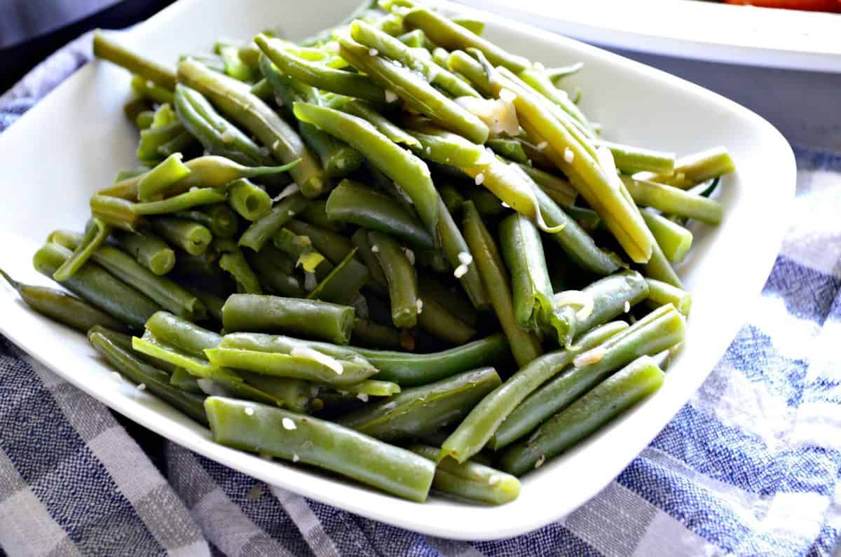 plated cooked green beans with minced garlic on top.