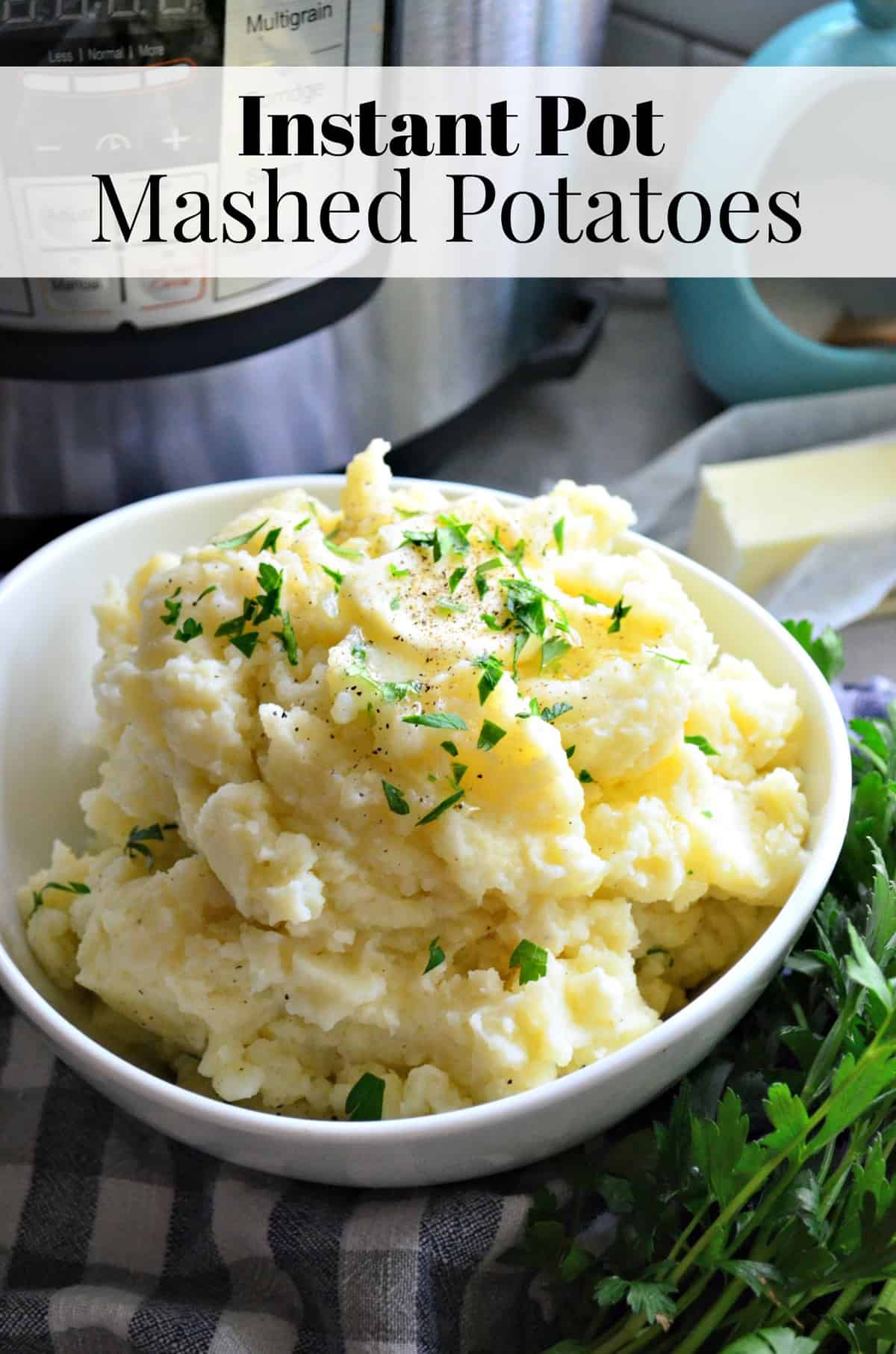 closeup bowl of mashed buttery potatoes with pepper and green herbs on top and title text.