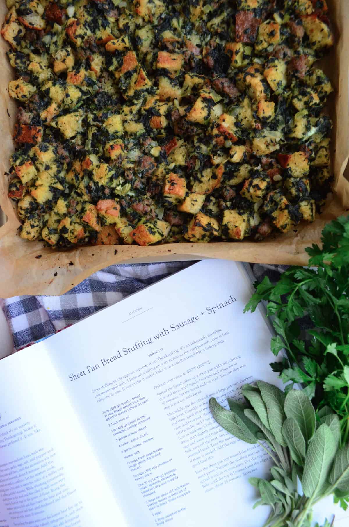 top view full of stuffing with chopped green herbs on parchment paper on sheet pan.