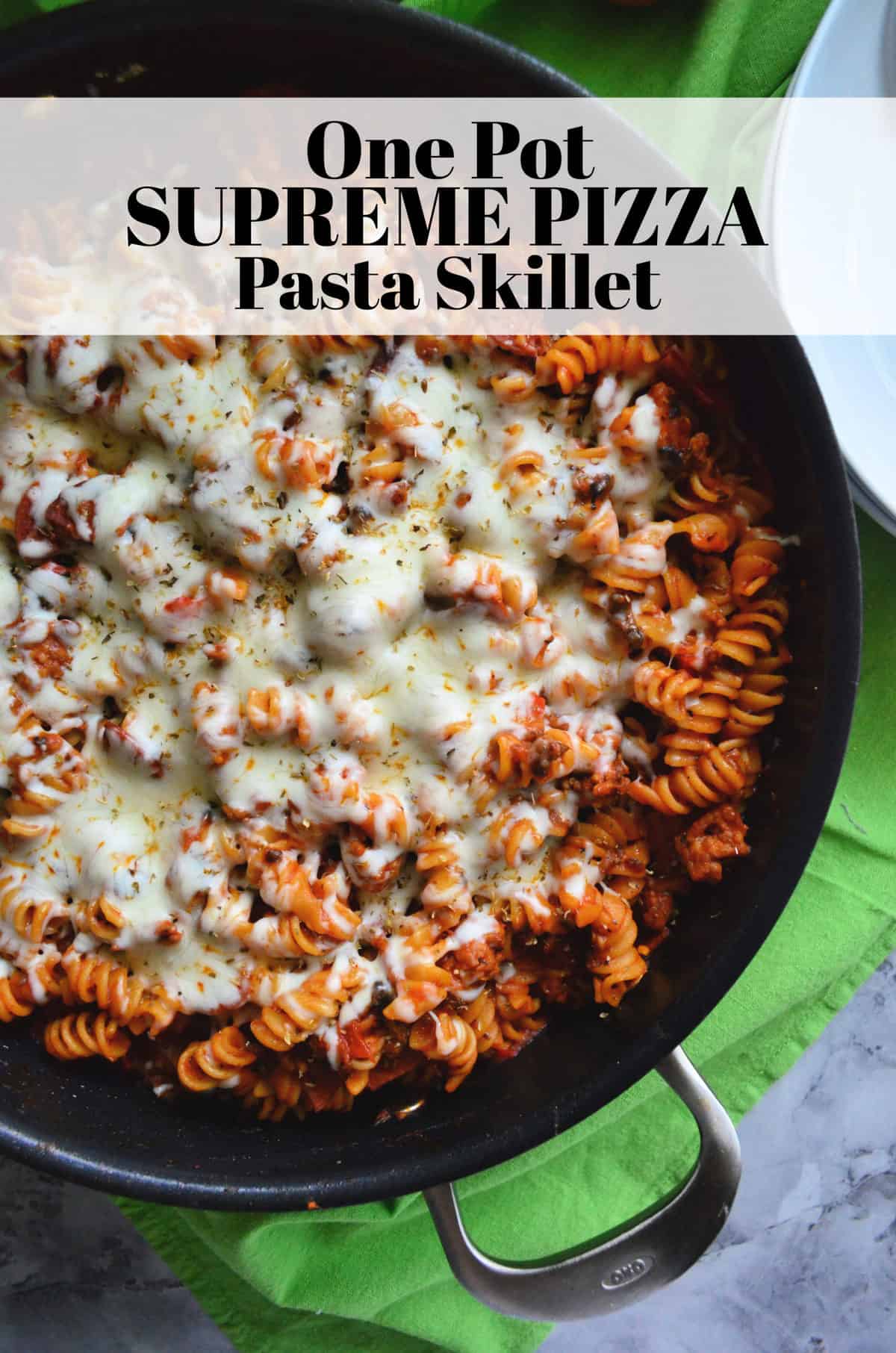 top view of skillet with rotini in red sauce topped with herbs and melted white cheese with title text.