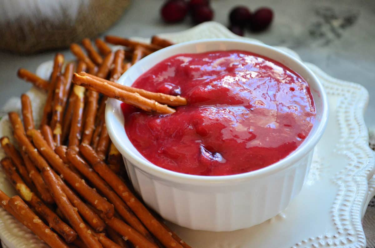 Small bowl of pink sauce on plate with pretzels.