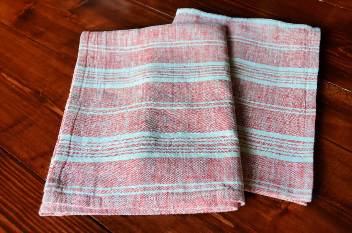 LinenMe Multistripe Hand And Guest Towels, Red White on hardwood floor.