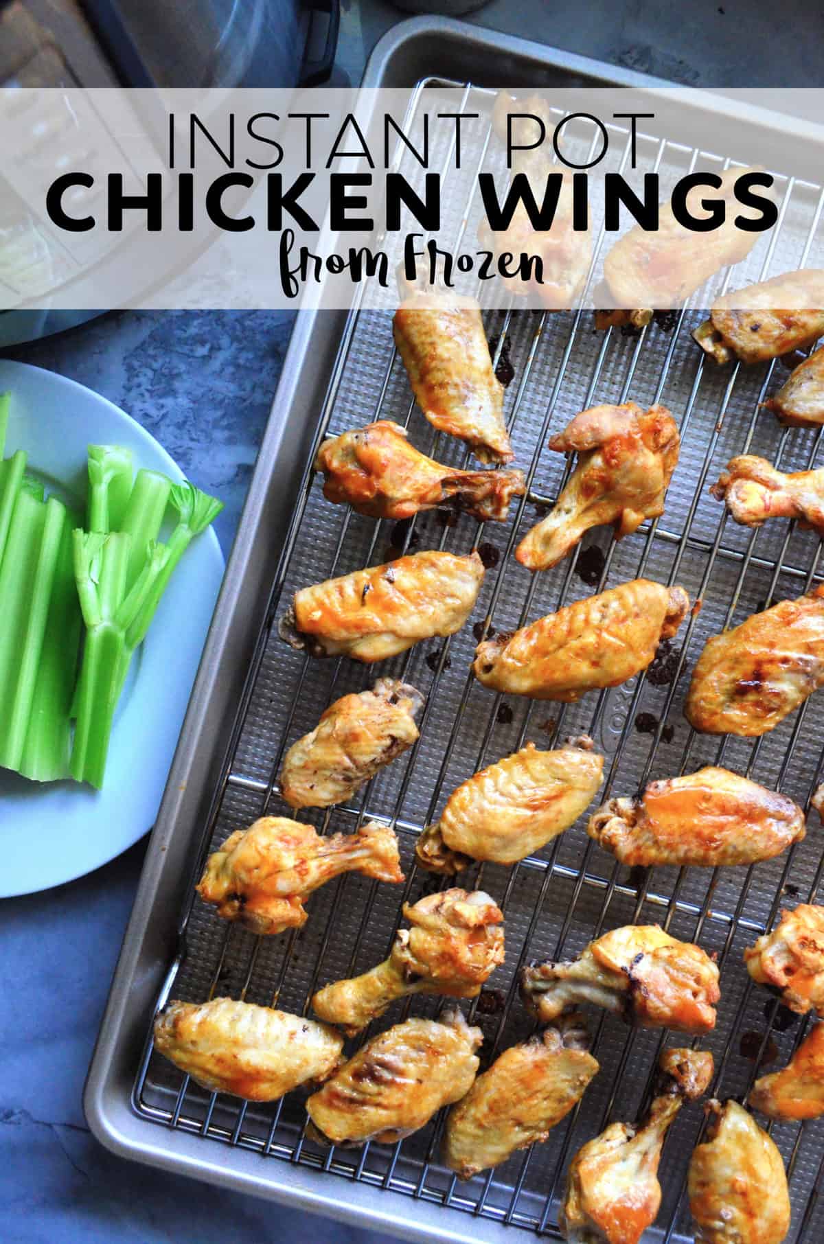 Top view chicken wings on metal rack placed on sheet pan next to celery plate with title text.