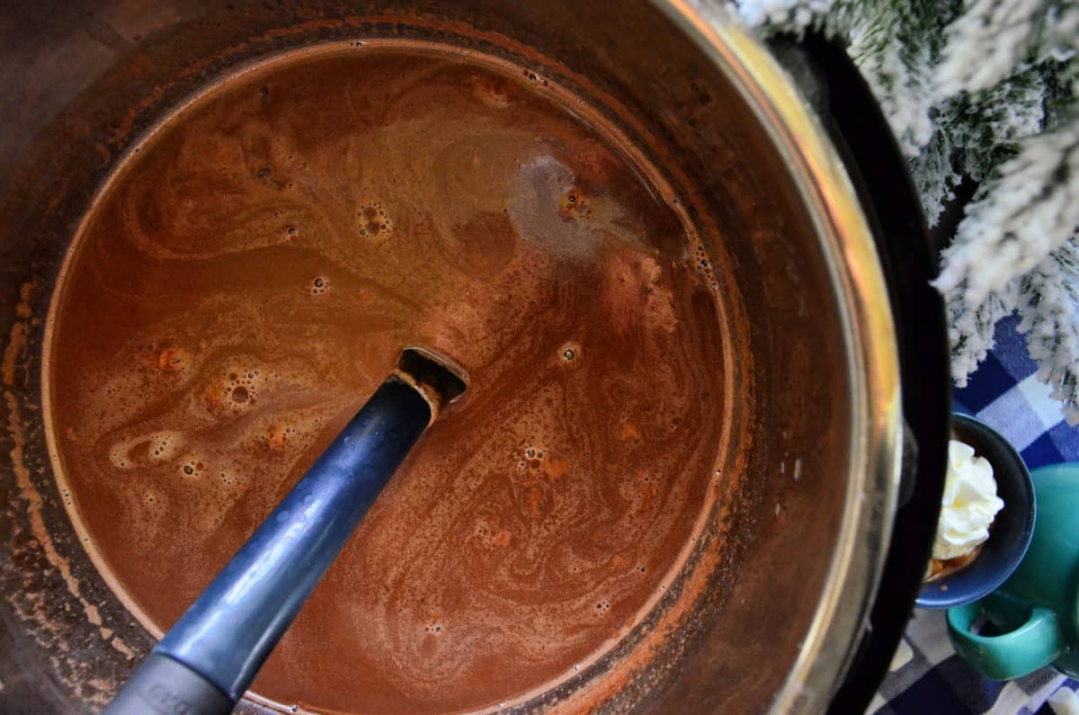 top view of spatula in brown liquid in the instant pot.