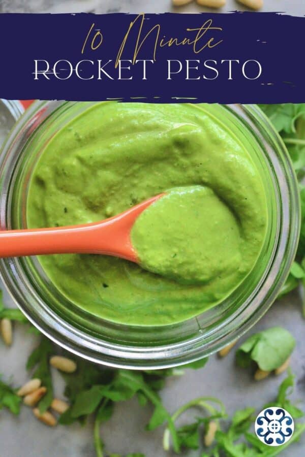 Top view of a glass jar with an orange spoon and bright green sauce with text on image for Pinterst.