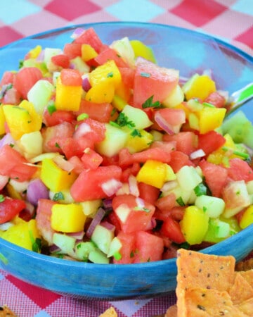 Blue bowl with watermelon salsa inside with a spoon.