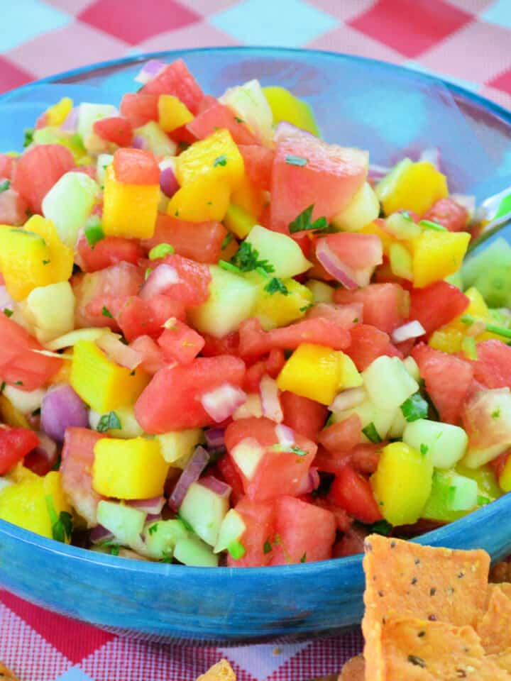 Blue bowl with watermelon salsa inside with a spoon.