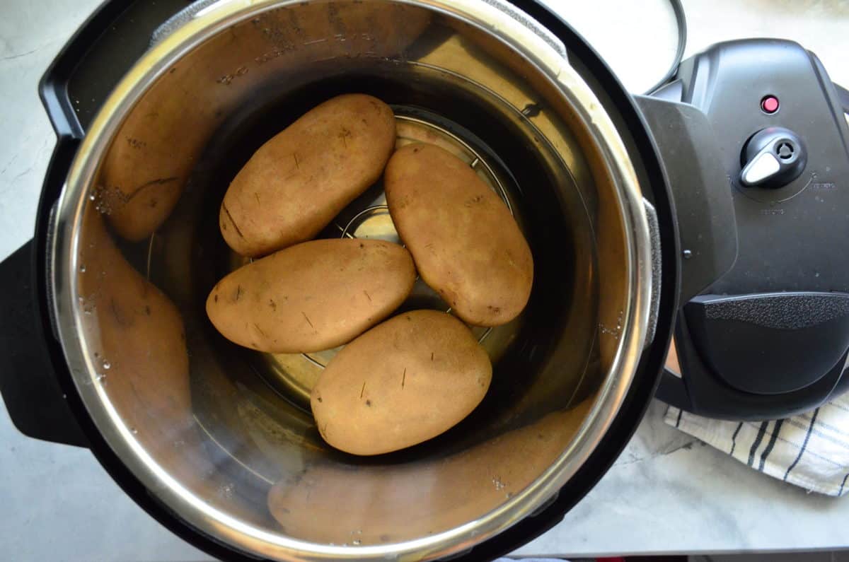 top view 4 whole potatoes with skins still on in instant pot.