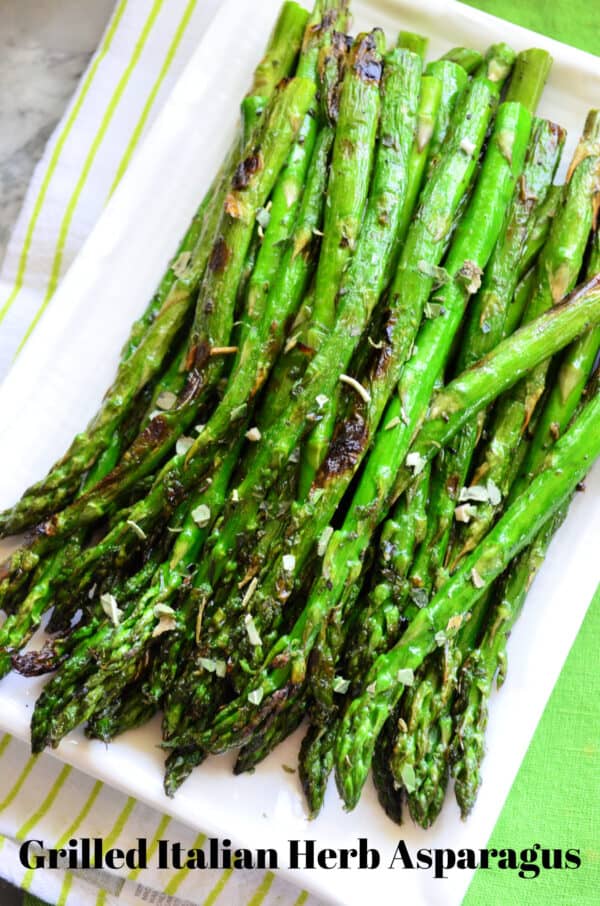 Top view of Grilled Italian Herb Asparagus on rectangle plate with pinterest title text.