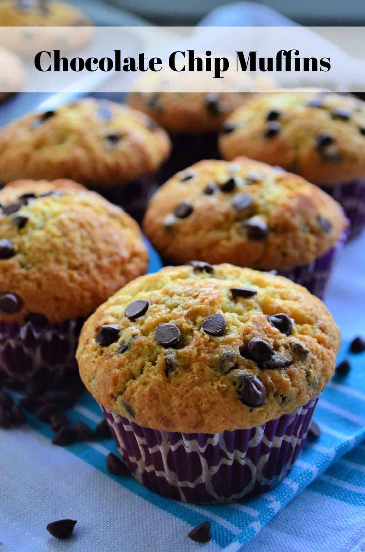 Close up of golden brown chocolate chip muffins on blue striped cloth with title text.