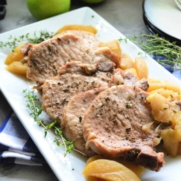 Rectangular plate of pork chops with cooked apples.