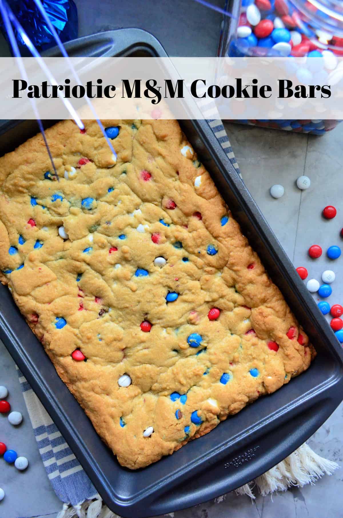A 9x13 metal pan of cookie bars that have red, white, and blue M&M's in them.