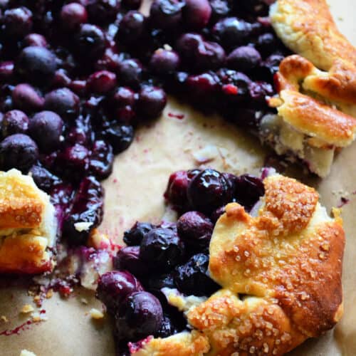 Close up of cooked blueberries in golden brown pastry crust with pinterest title text.