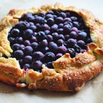 Top View of cooked blueberries in circular golden brown pastry crust.