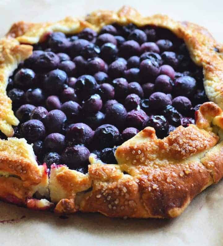 Top View of cooked blueberries in circular golden brown pastry crust.