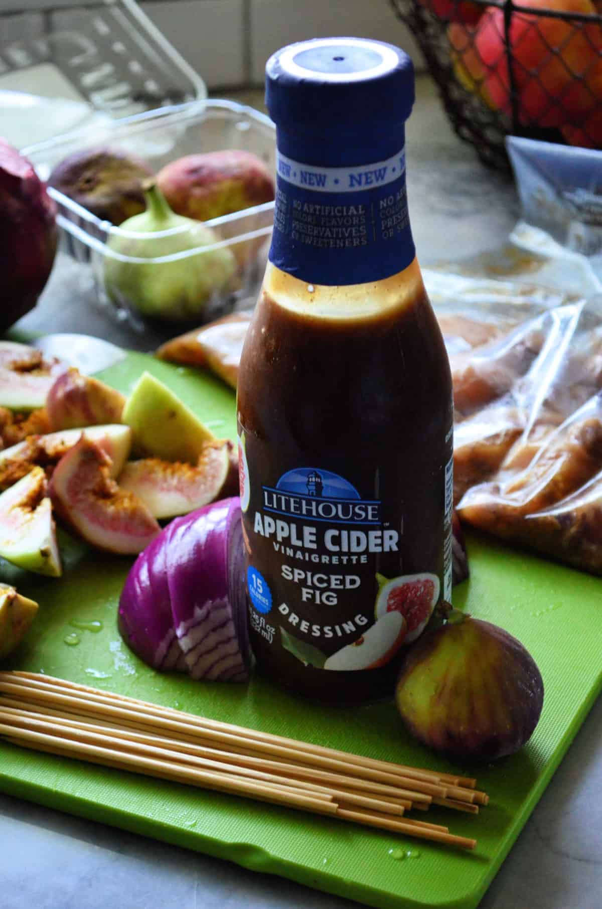 Bottle of Litehouse Apple cider vinaigrette spiced fig dressing on cutting board with skewer ingredients.