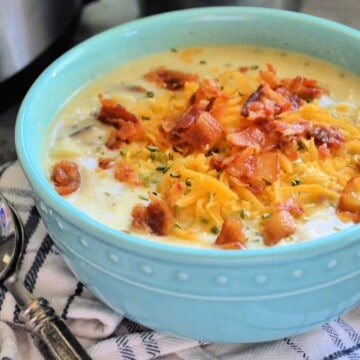 Side View of Bowl of Loaded Baked Potato Soup topped with shredded cheese and bacon.