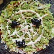 Guacamole Dip topped with Olives arranged to look like spiders and dressing to look like web.