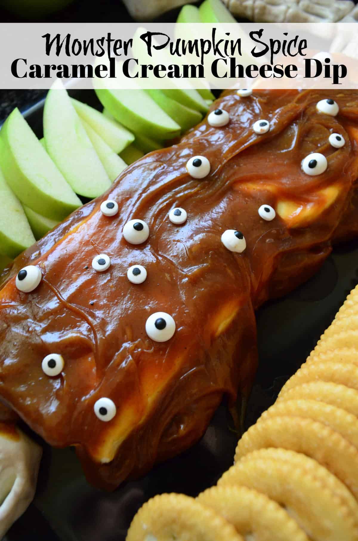 rectangle of cream cheese covered in caramel and candy eyes served with apples and crackers. Title text.