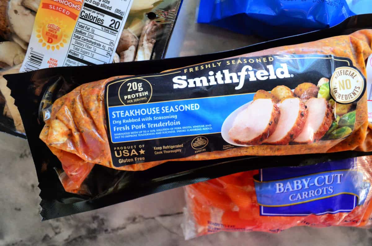 Smithfield® Steakhouse Seasoned Fresh Pork Tenderloin with slow cooker ingredients in packages on countertop.