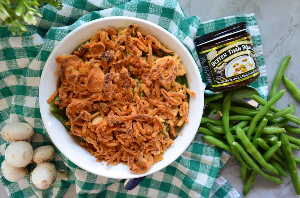 casserole dish with french fried onions next to green beans, mushrooms, and better than bouillon.