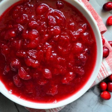 Top view of a white bowl with cranberry sauce inside it.