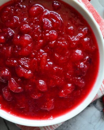 Top view of a white bowl with cranberry sauce inside it.