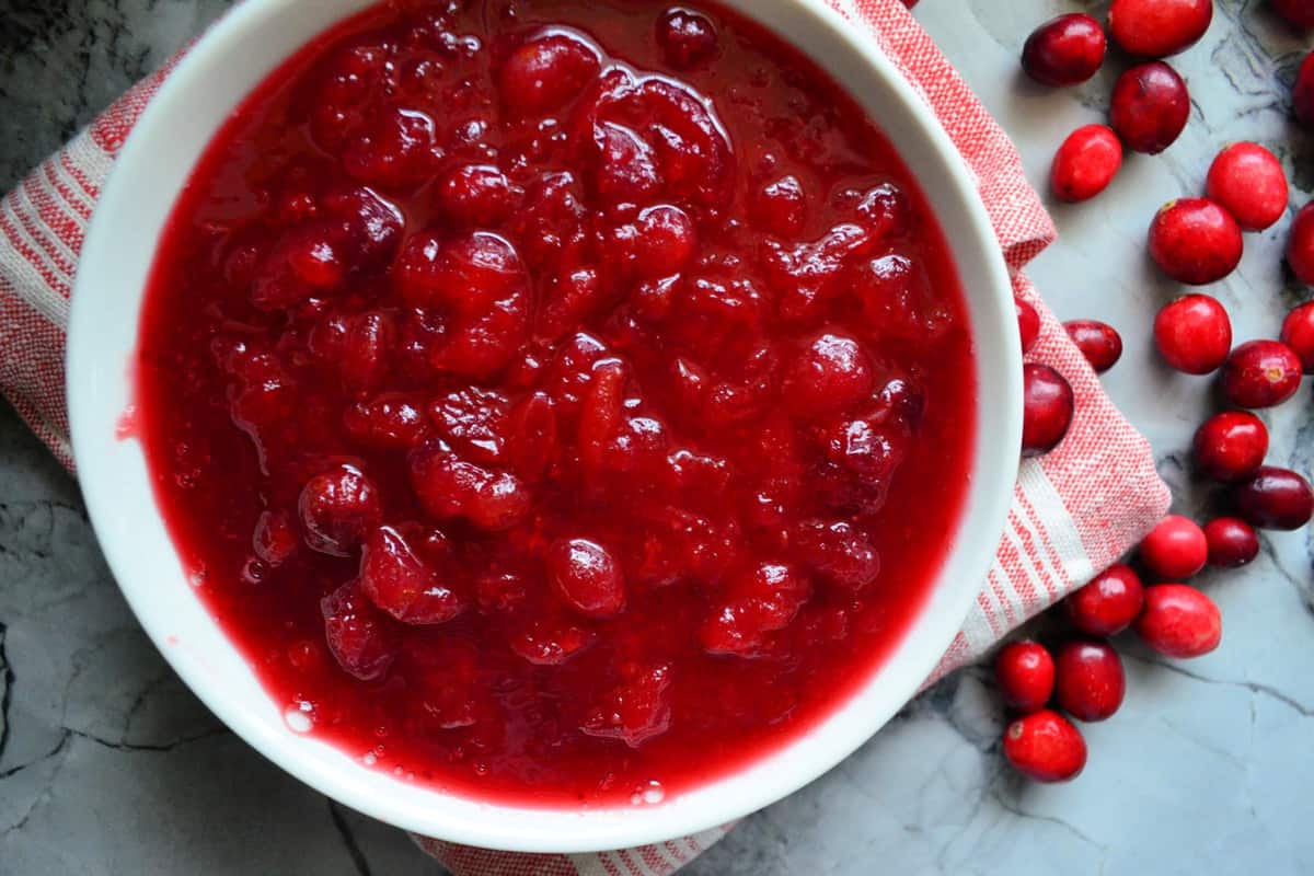 Top view of a white bowl with cranberry sauce inside it.