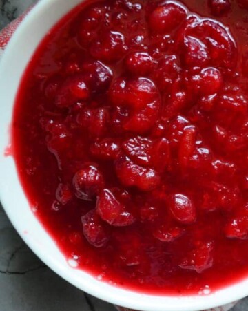Top view of a white bowl with cranberry sauce inside it.