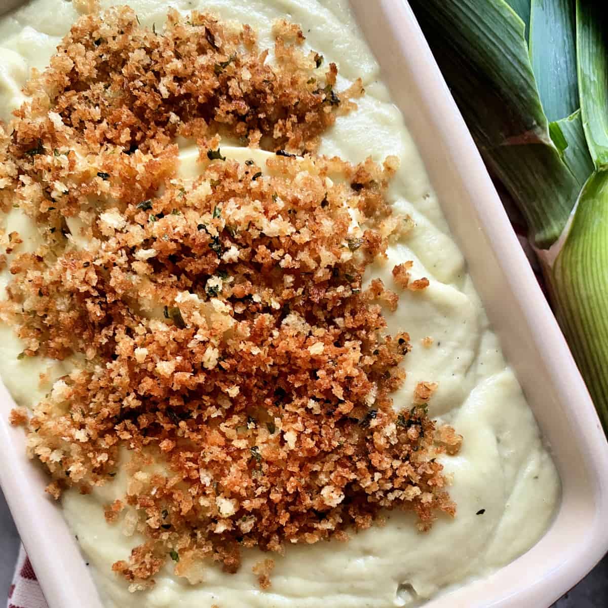 Rectangular dish with Cauliflower puree with breadcrumbs.