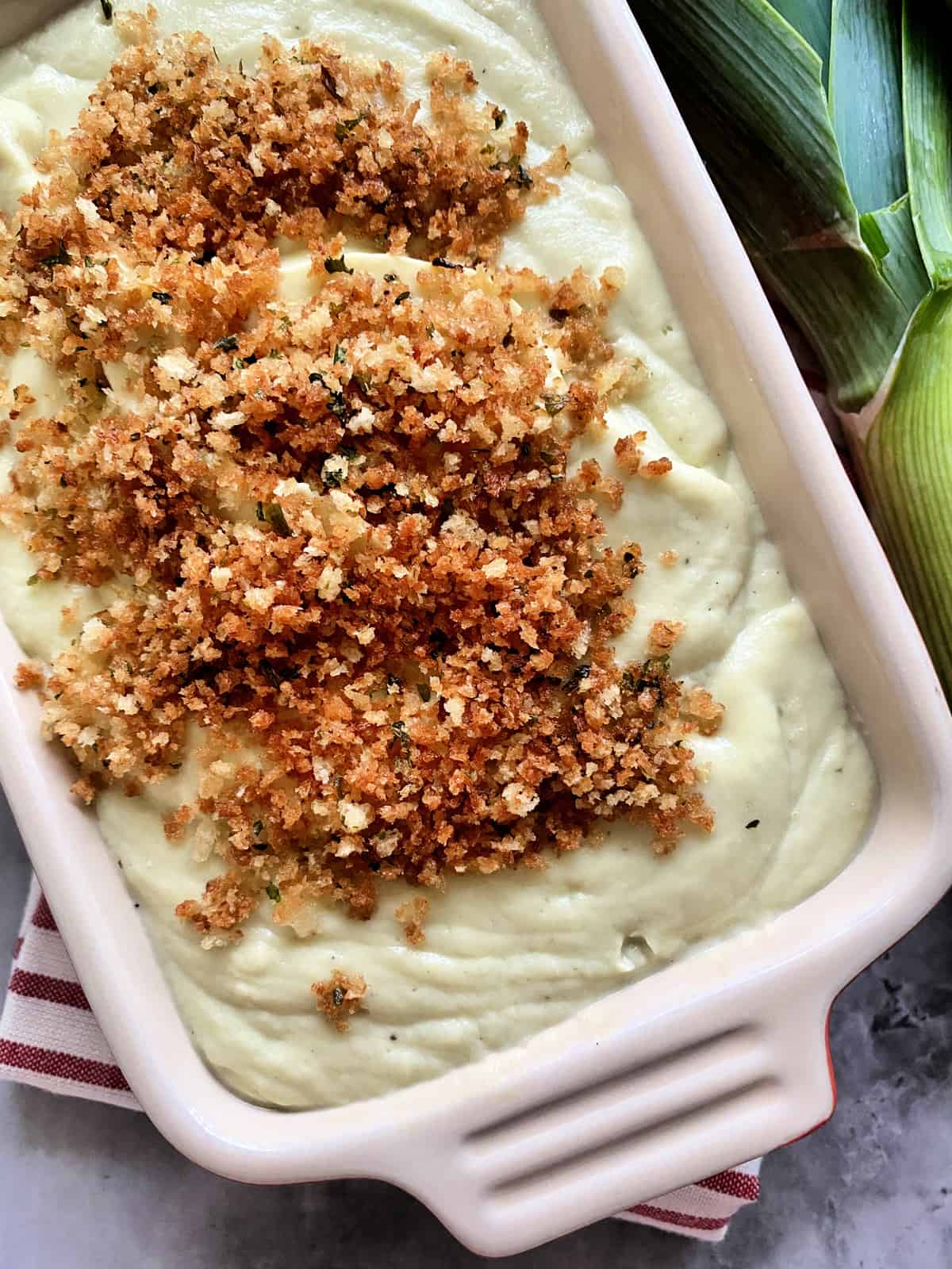 Cauliflower-Leek Puree in a baking dish with panko breadcrumbs on top