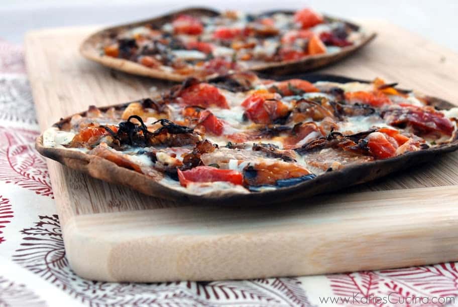 Side view of crisp Grilled Flatbread w/ Hot Italian Sausage, Peppers, & Caramelized Onions.
