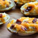 Bacon and Cheese Twice Baked Potatoes on wood cutting board.