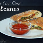 Horizontal view of Calzone plated with marinara sauce. Pinterest Title Text.